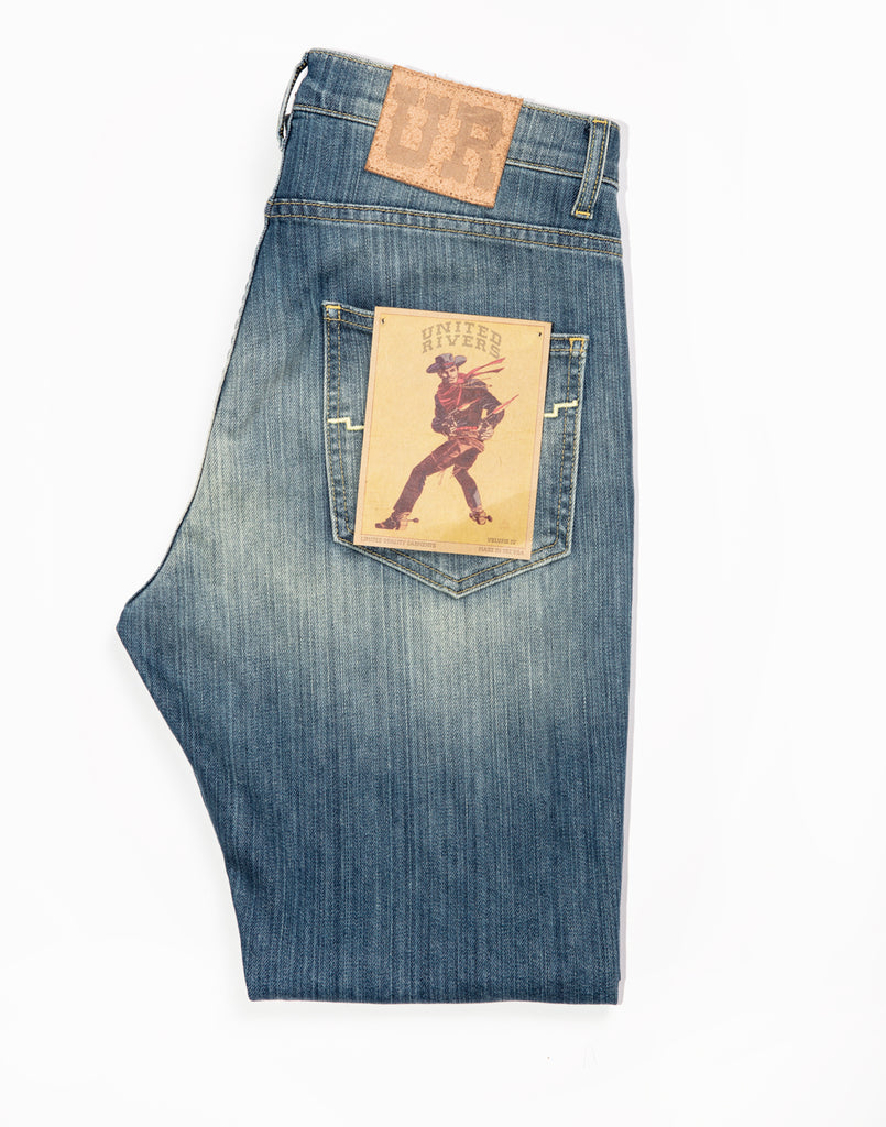 United Rivers Kansas River medium wash denim jeans  with leather “UR” signature patch at the back right waist